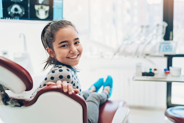 Portrait of a smiling girl sitting on a dentist's chair
