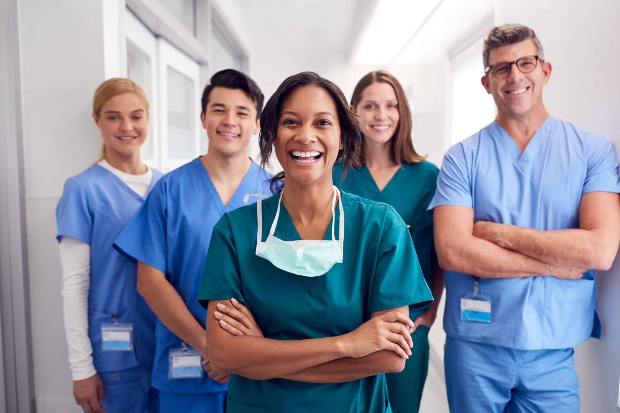 Portrait Of Laughing Multi-Cultural Medical Team Standing In Hospital Corridor Portrait Of Laughing Multi-Cultural Medical Team Standing In Hospital Corridor