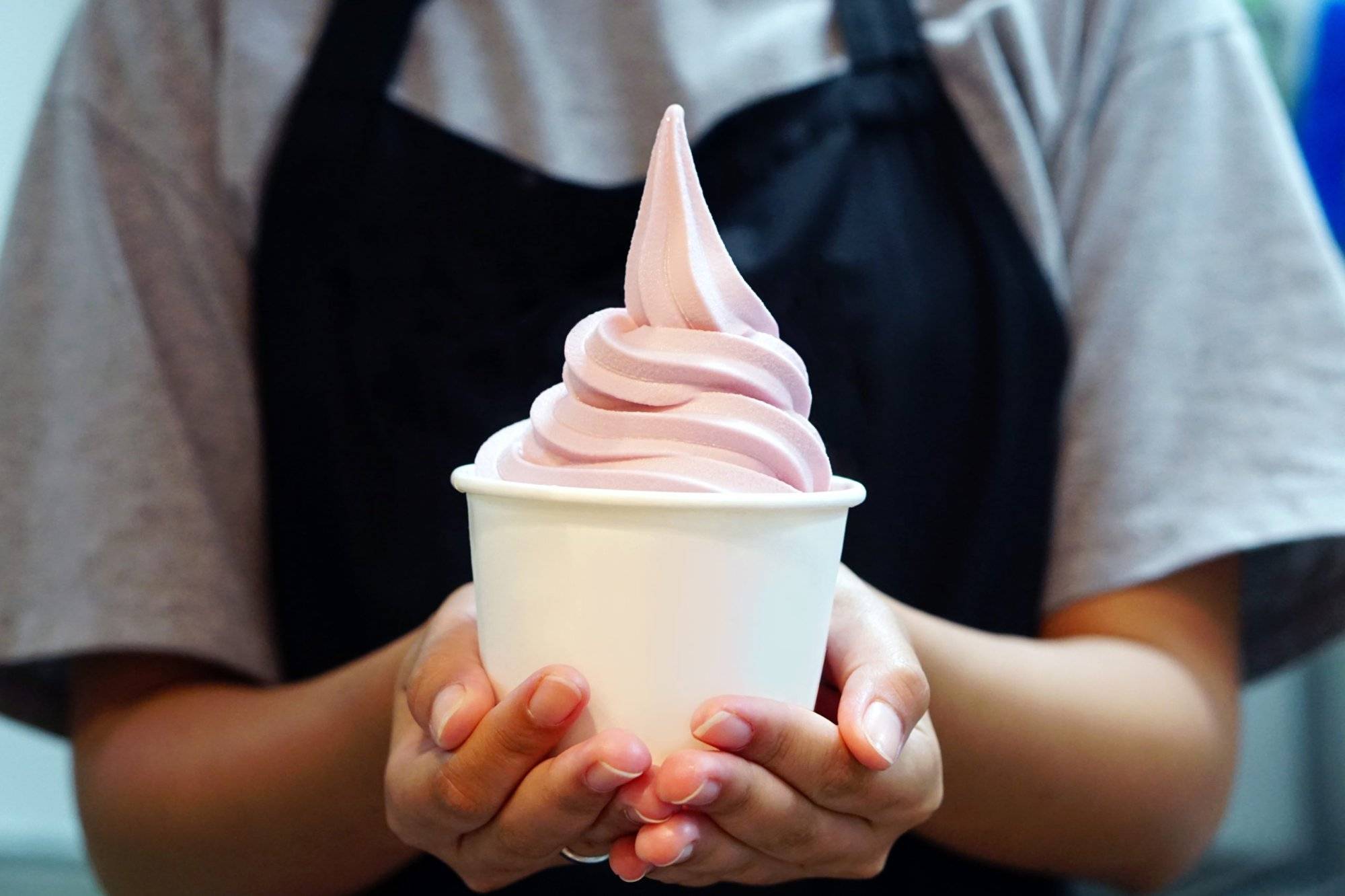 Closeup of woman ‘s hand holding takeaway cup with organic frozen yogurt ice cream, It’s delicious and healthy enjoy eating concept. Closeup of woman 's hand holding takeaway cup with organic frozen yogurt ice cream, It's delicious and healthy enjoy eating concept.