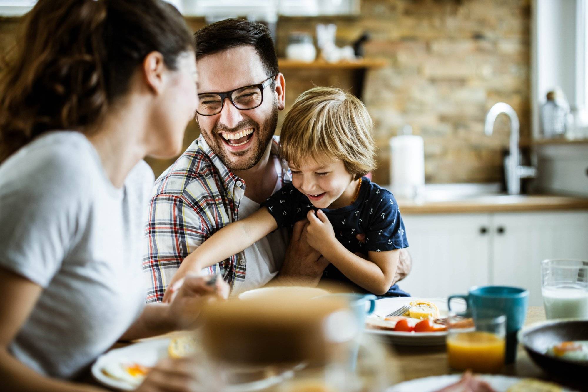 Young cheerful family having fun at dining table.