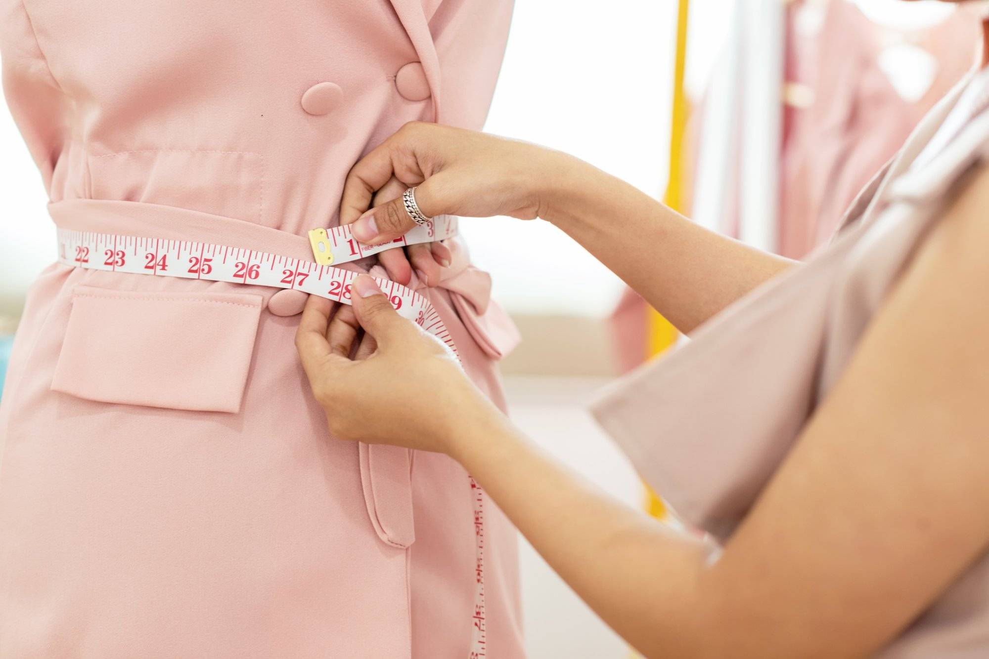 Close up hands Lifestyle Stylish tailor taking measurements on mannequin in studio. Woman fashion designer  working on her design in the showroom, Business small Concept