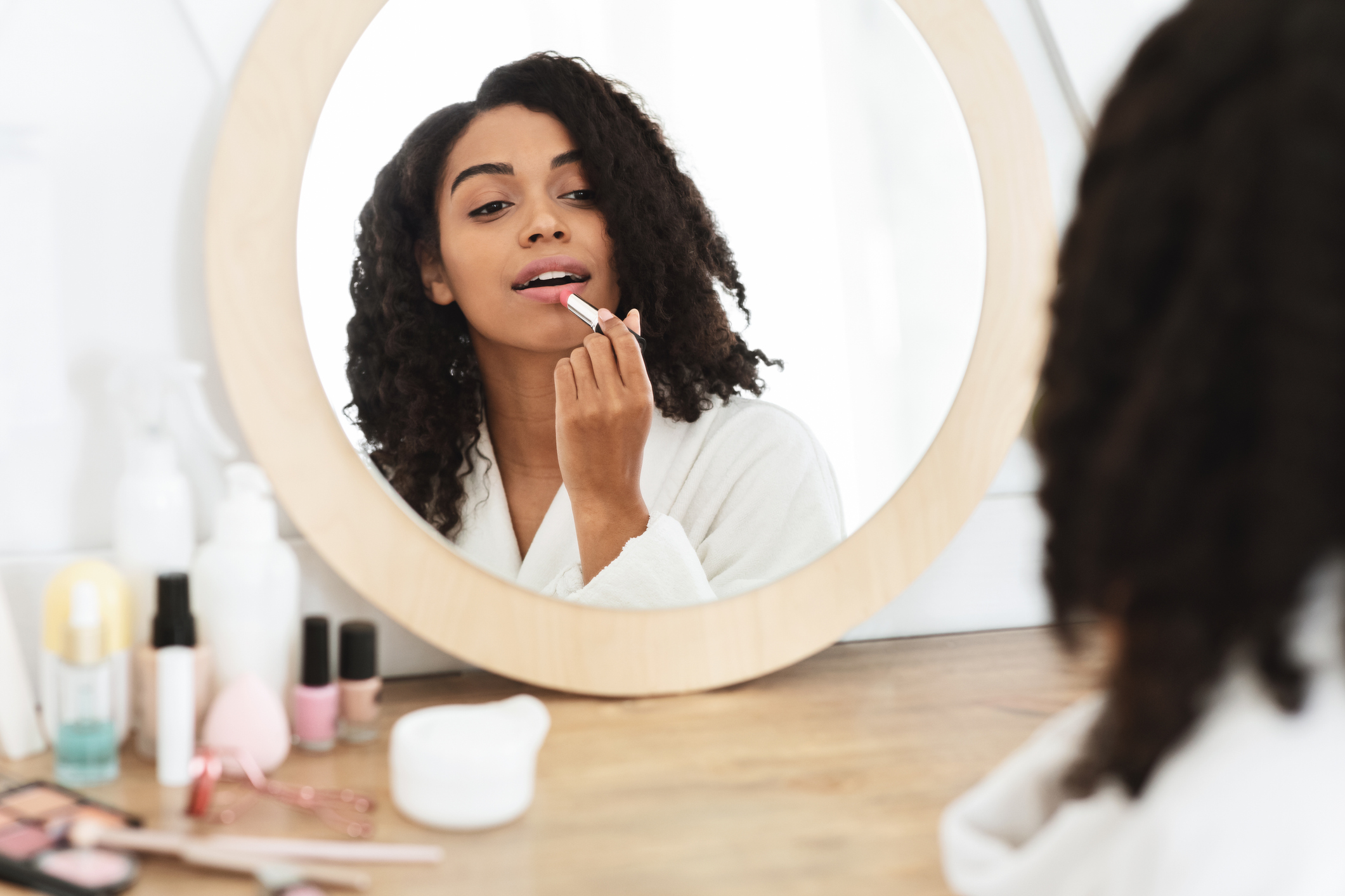 Beauty Portrait Of Black Girl Applying Pink Nude Lipstick In Front Of Mirror