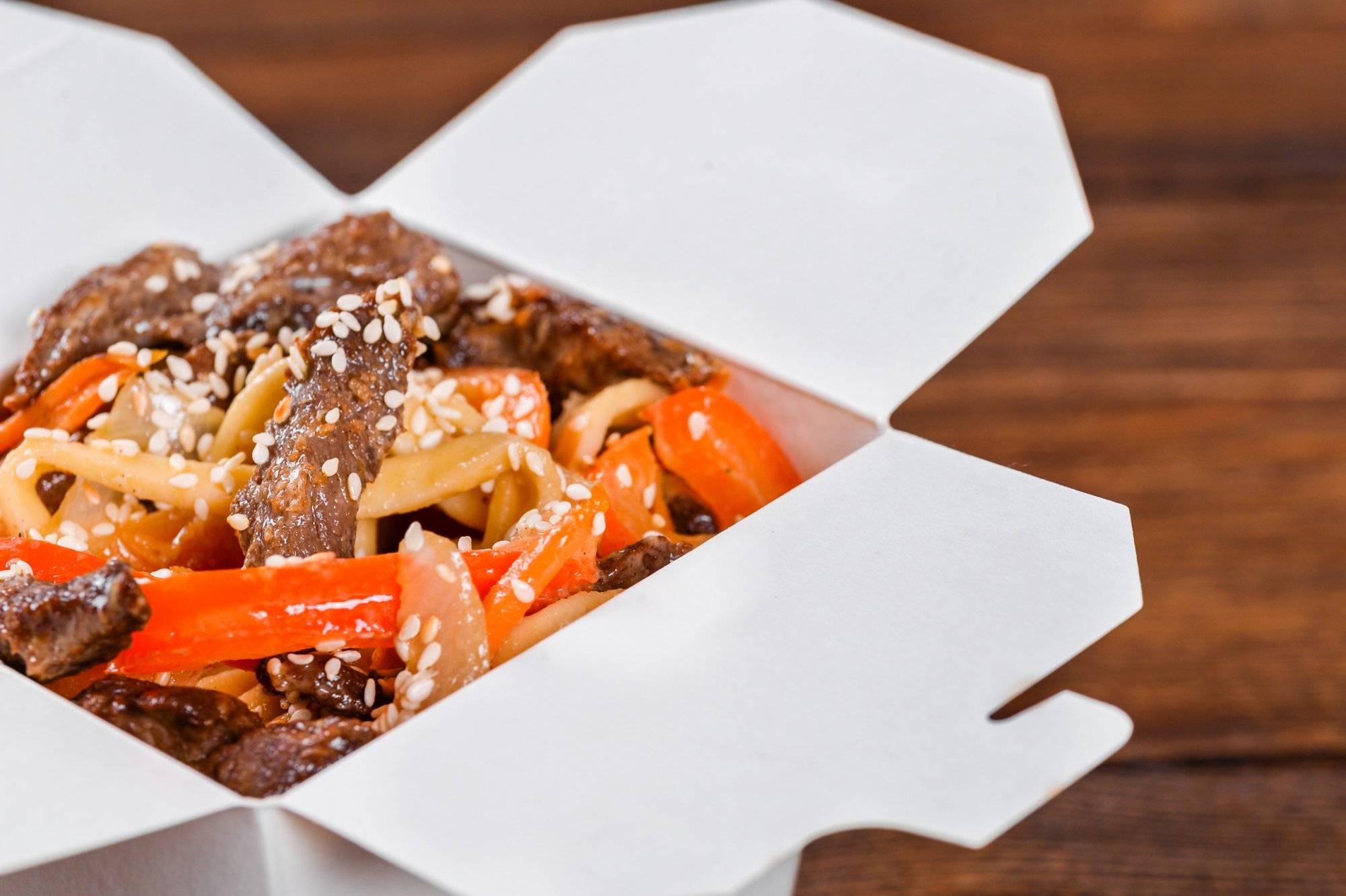 Noodles in a white box on wooden background